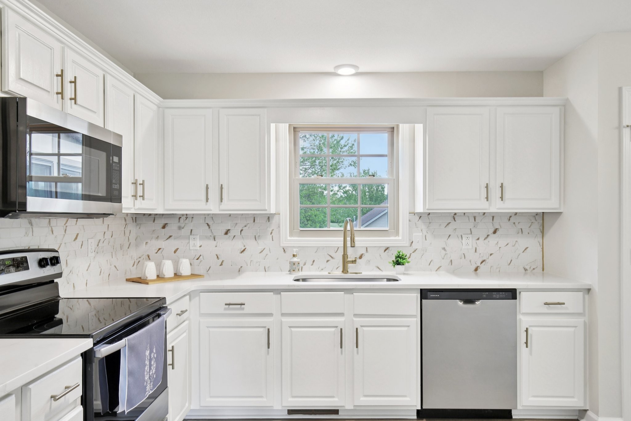 1698 Porter Road Bon Aqua, TN 37025 - Photo 6 of 24 a kitchen with granite countertop white cabinets white appliances a sink and a window