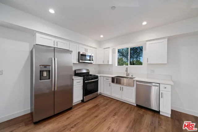 a kitchen with stainless steel appliances a refrigerator a sink a stove a microwave and cabinets