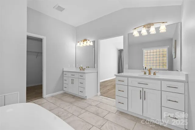 a view of an empty room with window and chandelier fan