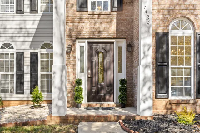 a view of an entryway with wooden floor and a kitchen view