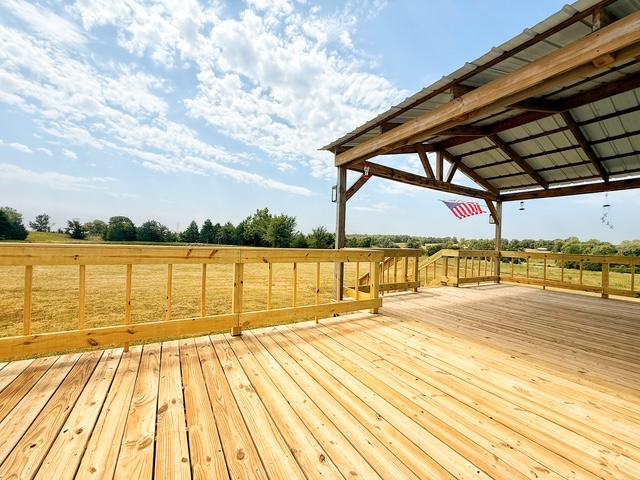 36469 1330th Road Wewoka, OK 74884 - Photo 20 of 39 Expansive wood deck with a metal roof overhang, wooden railing, and open-air design