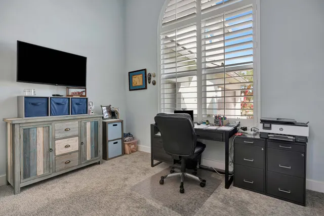 a view of a white house with a big yard plants and large trees