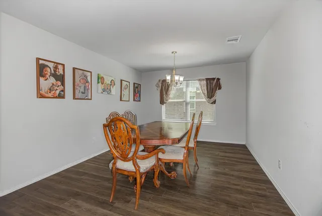 a dining room with furniture a chandelier and wooden floor