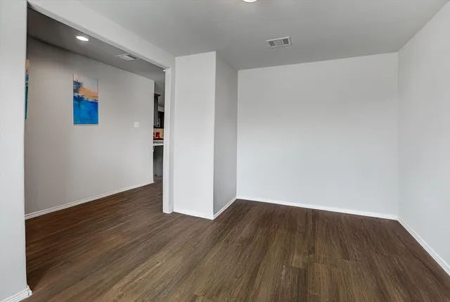 a view of an empty room with a window and brick walls