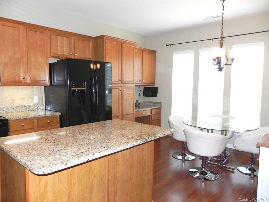 3030 Voyageurs Way Indian Land, SC 29707 - Photo 6 of 12 a kitchen with a table chairs refrigerator and cabinets