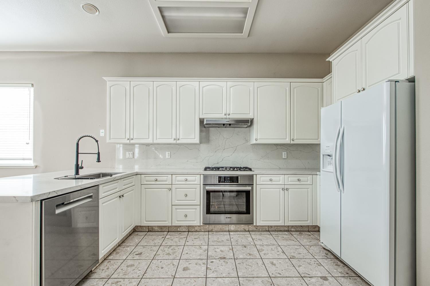 2140 West Rue St Michel Fresno, CA 93711 - Photo 18 of 36 a kitchen with white cabinets stainless steel appliances and a sink