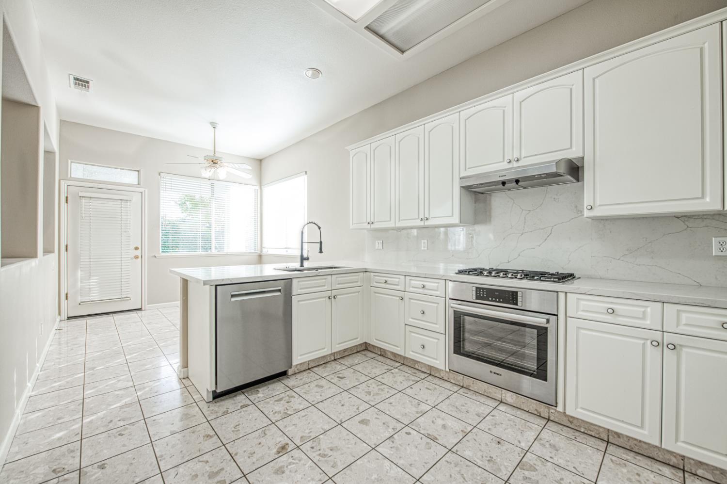 2140 West Rue St Michel Fresno, CA 93711 - Photo 19 of 36 a kitchen with white cabinets and white appliances