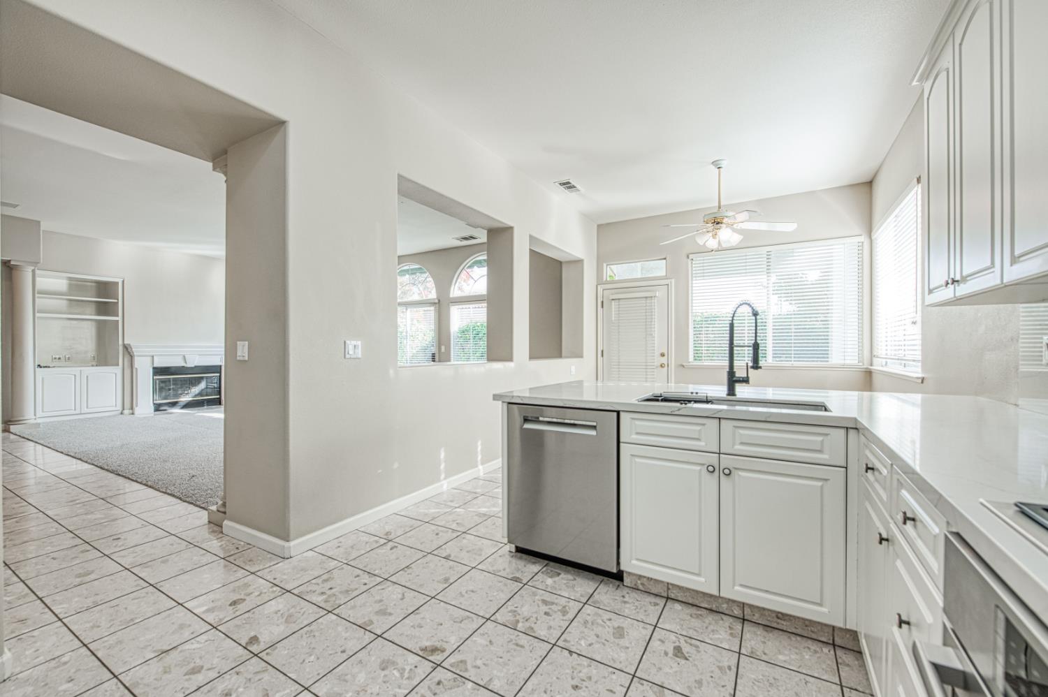 2140 West Rue St Michel Fresno, CA 93711 - Photo 21 of 36 a large white kitchen with a sink and dishwasher a stove with wooden floors