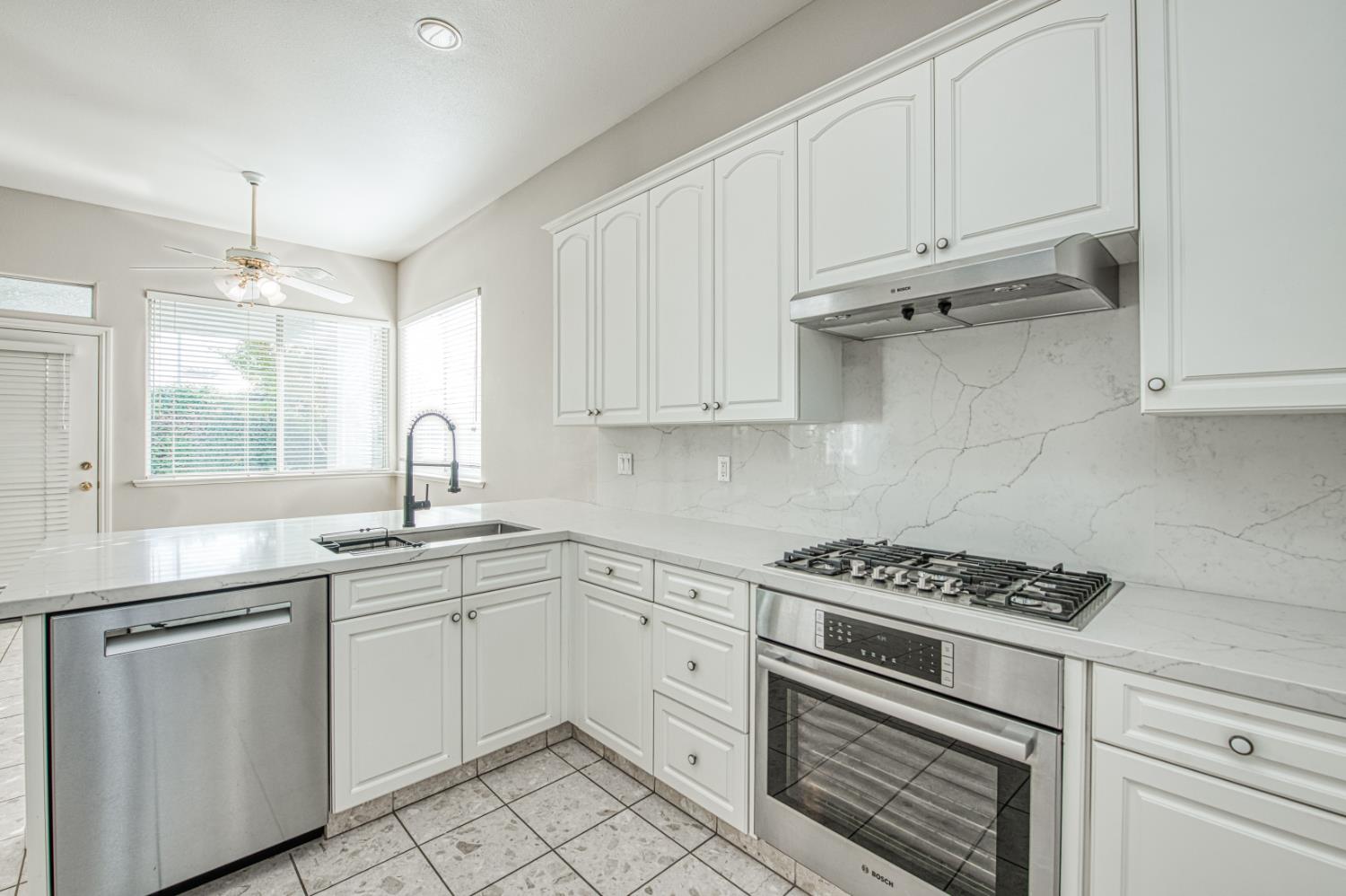 2140 West Rue St Michel Fresno, CA 93711 - Photo 22 of 36 a kitchen with white cabinets and appliances