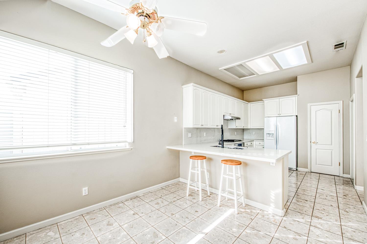 2140 West Rue St Michel Fresno, CA 93711 - Photo 24 of 36 a kitchen with kitchen island granite countertop a stove a sink and a refrigerator