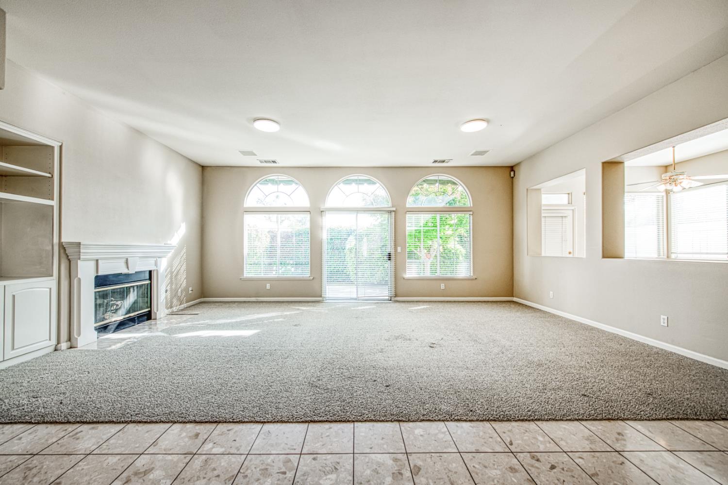 2140 West Rue St Michel Fresno, CA 93711 - Photo 10 of 36 a view of an empty room with a fireplace and a window