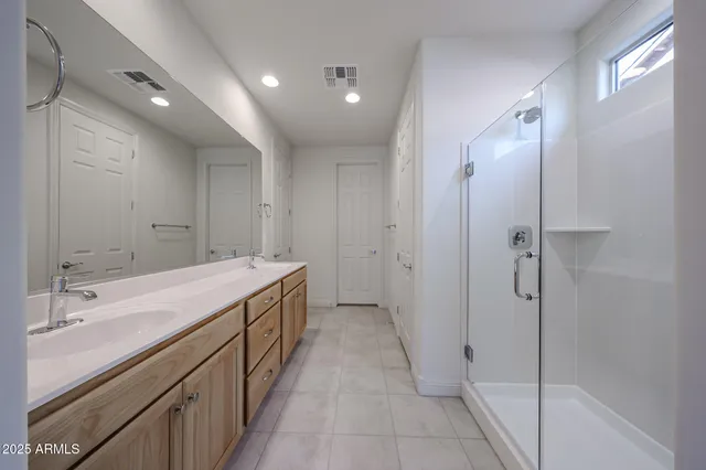a spacious bathroom with a granite countertop sink a mirror and a shower
