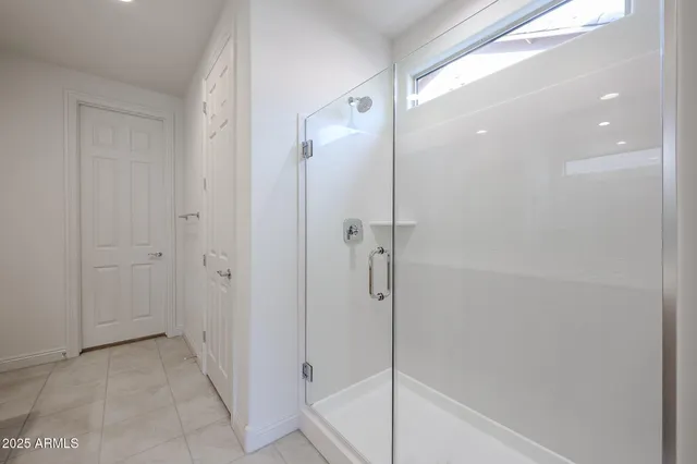 a bathroom with a shower and a glass door