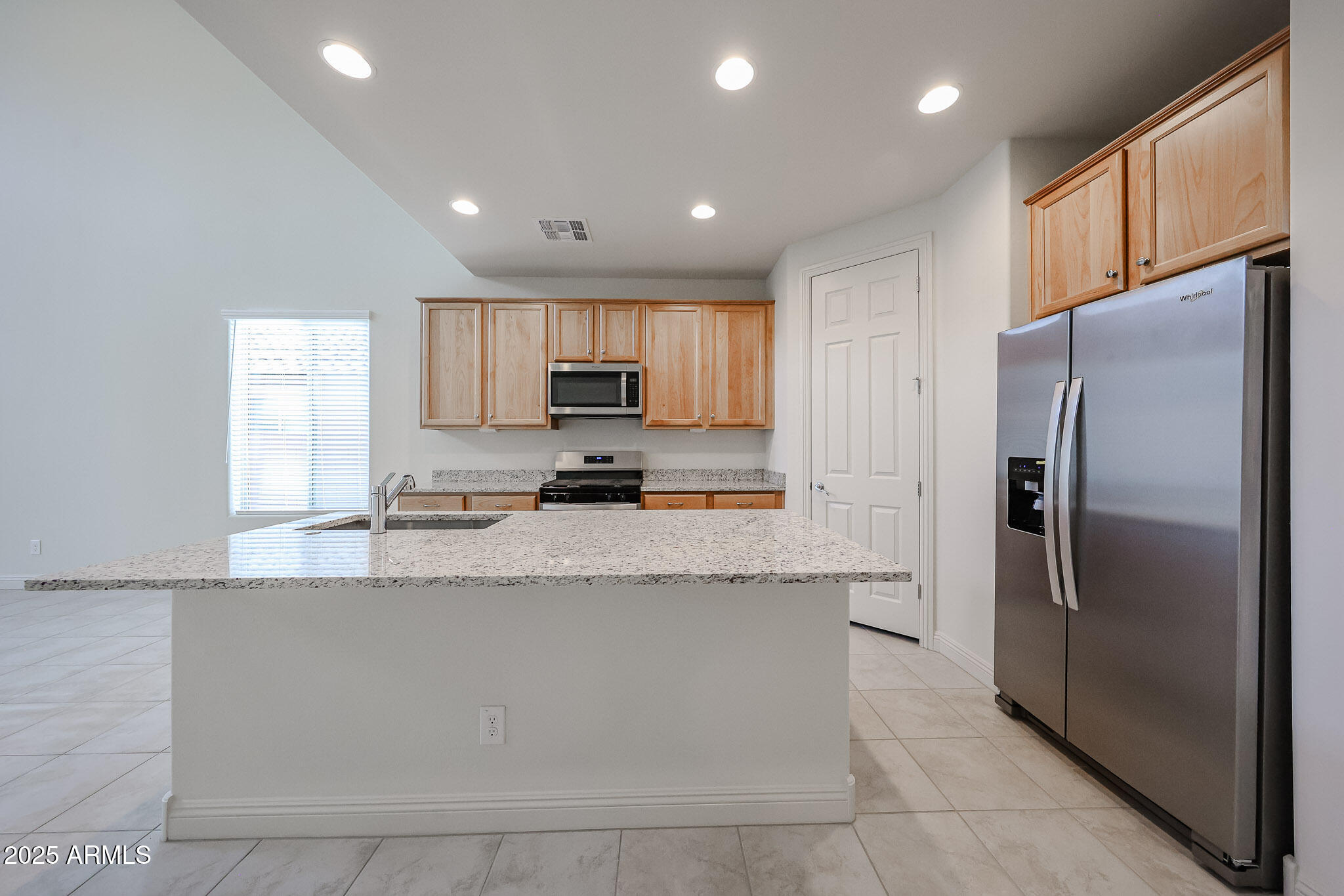 7072 West Oberlin Way Peoria, AZ 85383 - Photo 3 of 24 a kitchen with stainless steel appliances granite countertop a refrigerator a stove and a sink