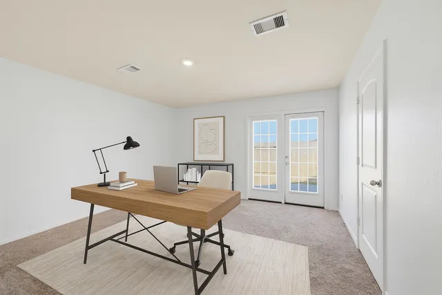 a view of a workspace with furniture and a window