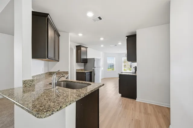 a kitchen with stainless steel appliances granite countertop a sink refrigerator and microwave