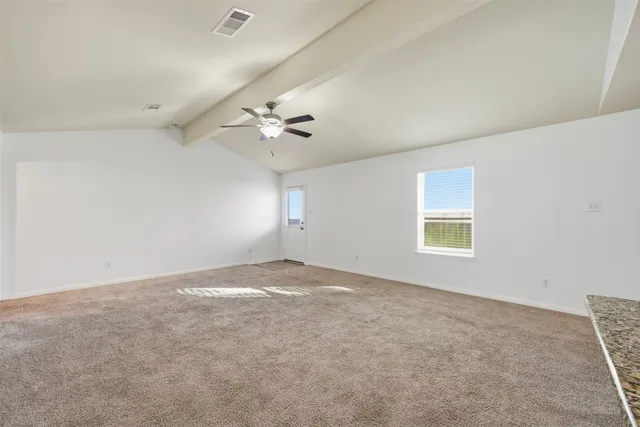 an empty room with windows and chandelier fan