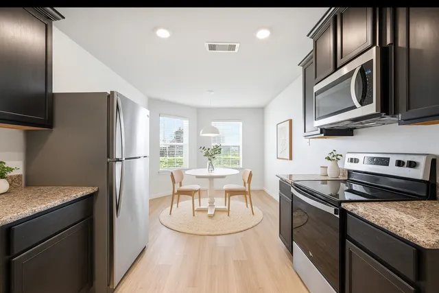 a kitchen with stainless steel appliances granite countertop a sink stove and refrigerator