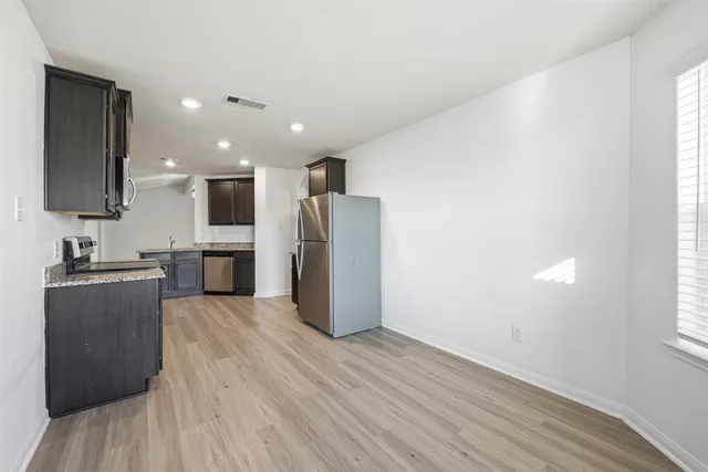 a view of a kitchen with a sink and a refrigerator