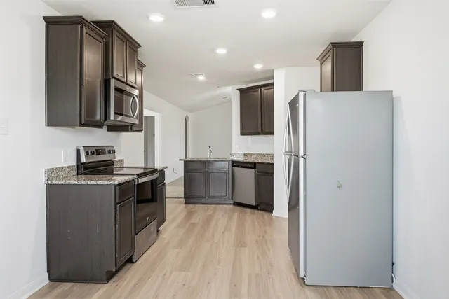a kitchen with stainless steel appliances a refrigerator stove and microwave