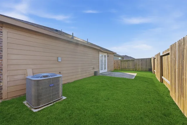 a view of a backyard with plants and large trees