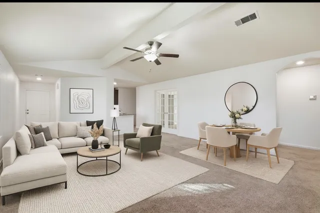 a living room with furniture a table and a chandelier