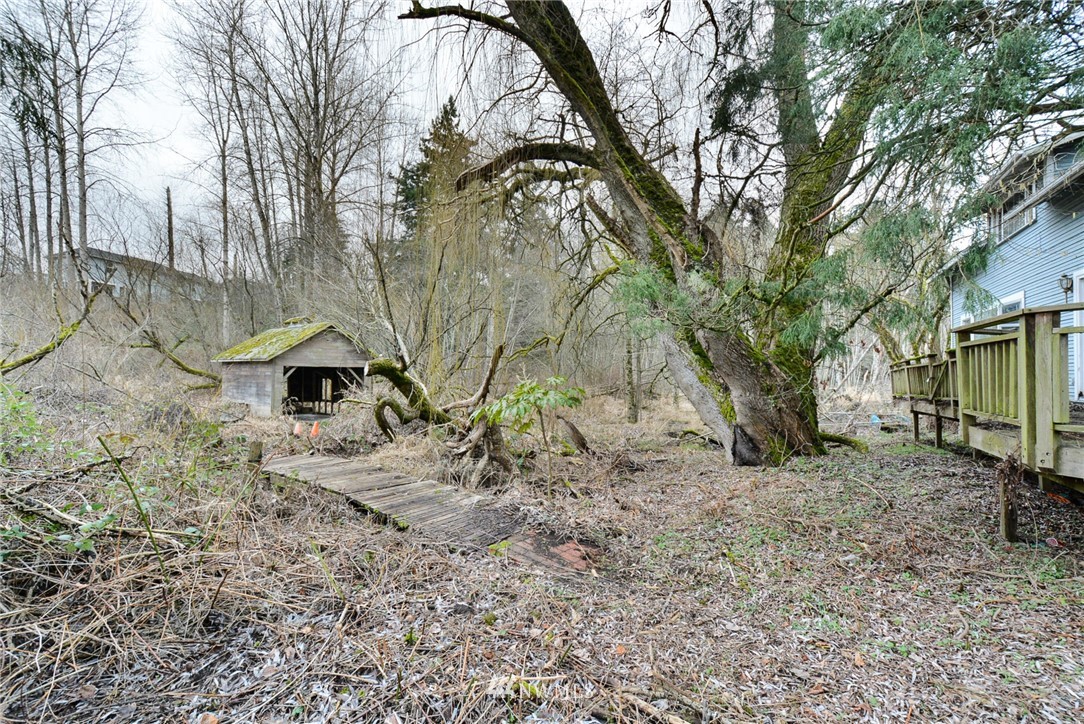 23004 Bothell Everett Highway Bothell, WA 98021 - Photo 7 of 23 a backyard of a house with large trees and wooden fence