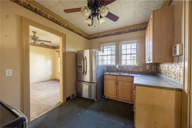 a kitchen with stainless steel appliances a refrigerator and a chandelier