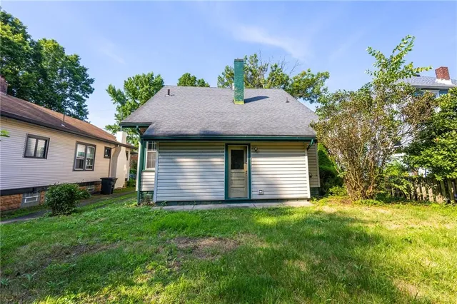 a aerial view of house with yard and trees in the background