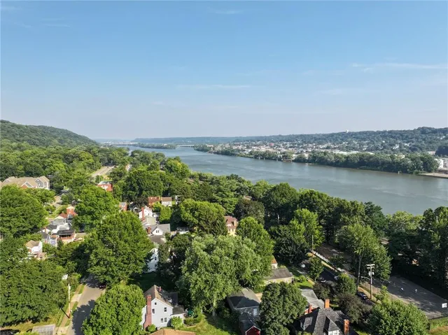 an aerial view of a houses with outdoor space and trees