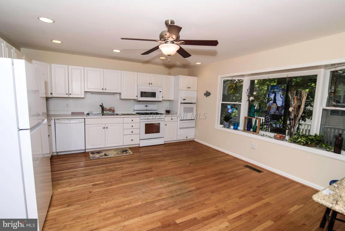 17 Mist Flower Road Ocean Pines, MD 21811 - Photo 6 of 49 a large white kitchen with stainless steel appliances granite countertop a stove and a refrigerator