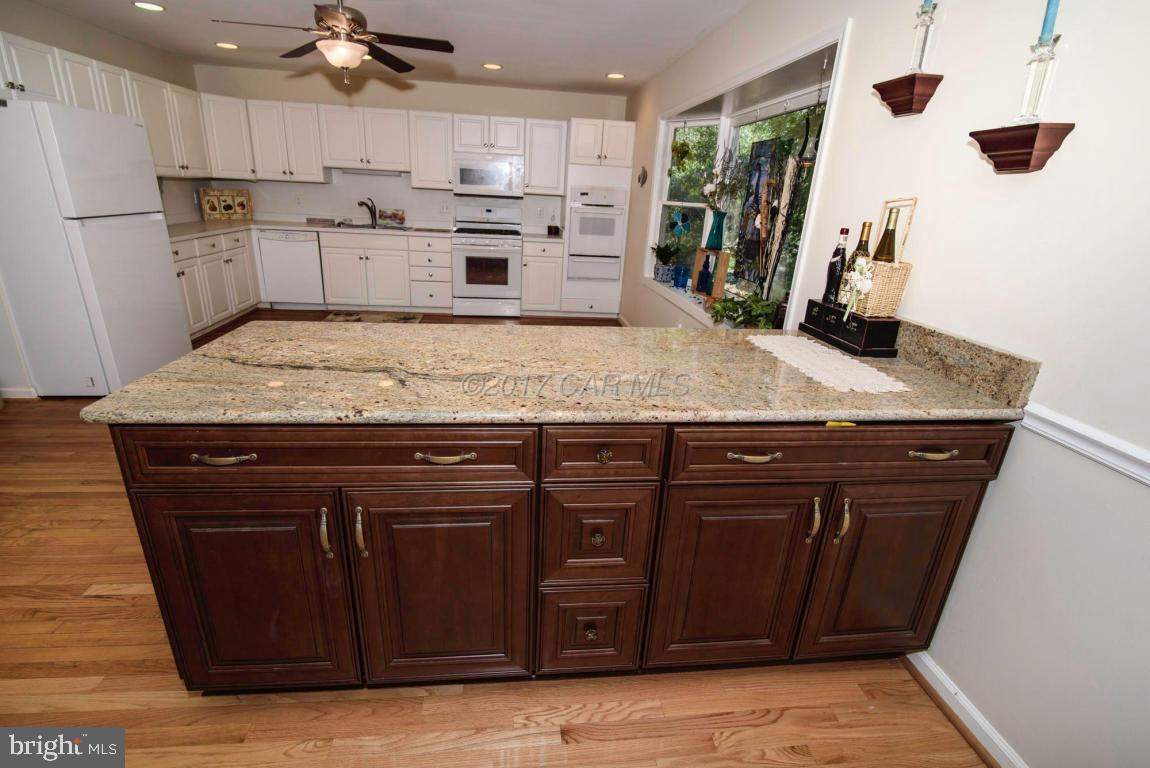 17 Mist Flower Road Ocean Pines, MD 21811 - Photo 10 of 49 a kitchen with stainless steel appliances granite countertop a sink dishwasher and a refrigerator with wooden floor