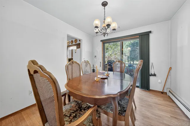 a dining room with furniture a chandelier and wooden floor