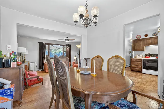 a dining room with furniture a chandelier and wooden floor