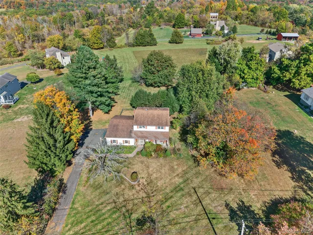an aerial view of a house with a yard and lake view