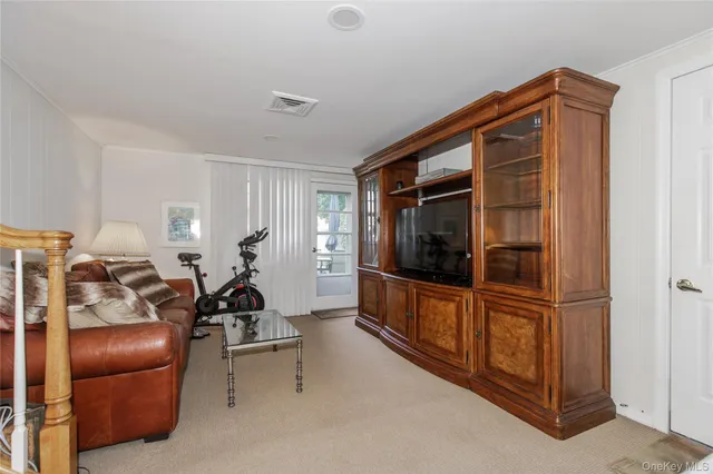 a living room with furniture a flat screen tv and a window
