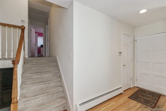a view of a hallway with wooden floor and staircase