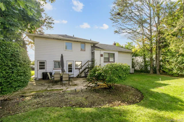 a view of a house with backyard and sitting area