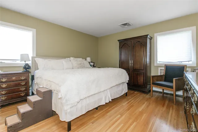 a bedroom with a bed a chair and a large window