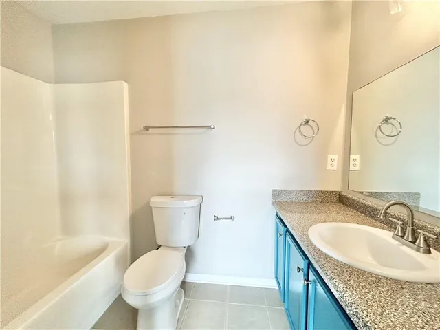 a bathroom with a granite countertop sink toilet and a bathtub
