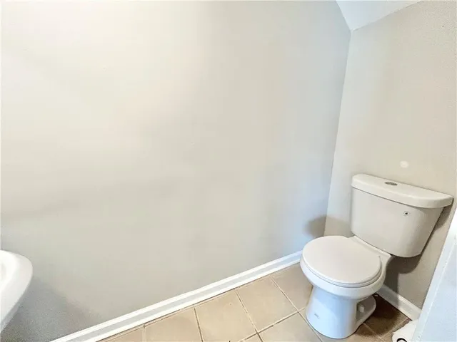 a white toilet sitting next to a white wall