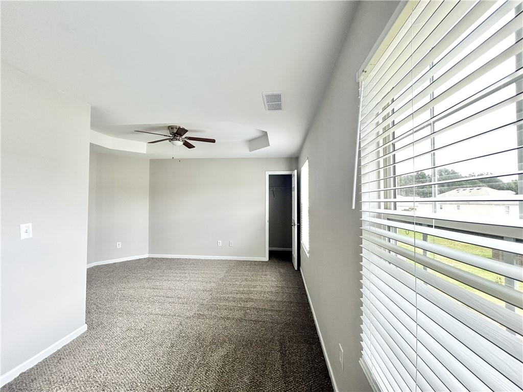 736 Wheel House Lane, Unit B Monroe, GA 30655 - Photo 3 of 15 an empty room with windows and chandelier