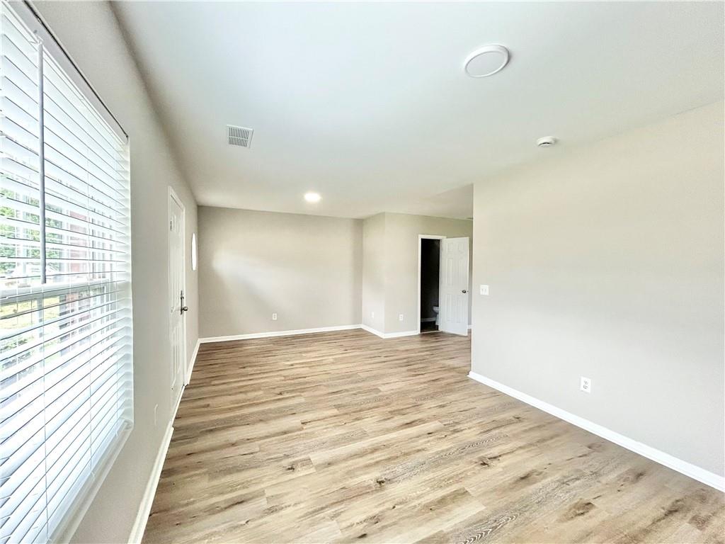 736 Wheel House Lane, Unit B Monroe, GA 30655 - Photo 4 of 15 a view of an empty room with wooden floor and a window