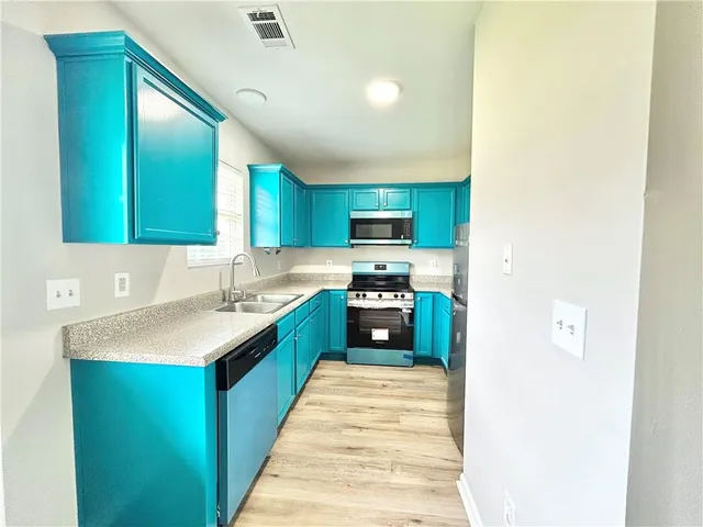 a kitchen with stainless steel appliances granite countertop a sink stove and refrigerator
