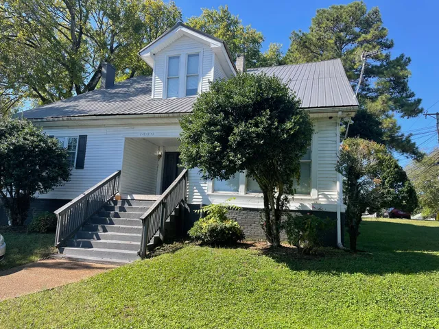 a front view of house with a yard and trees