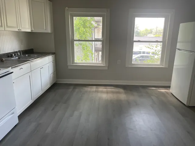 a kitchen with granite countertop wooden floors a sink and a window