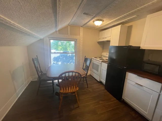 a kitchen with a table chairs and refrigerator