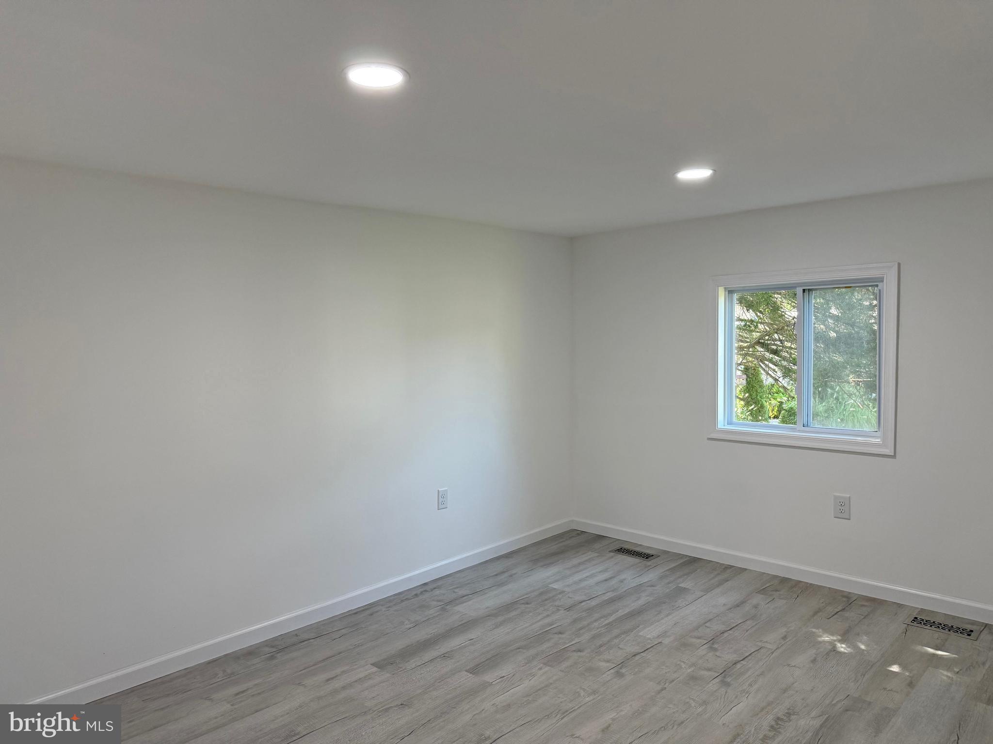 33308 Lighthouse Court, Unit D18 Lewes, DE 19958 - Photo 21 of 39 an empty room with wooden floor and windows