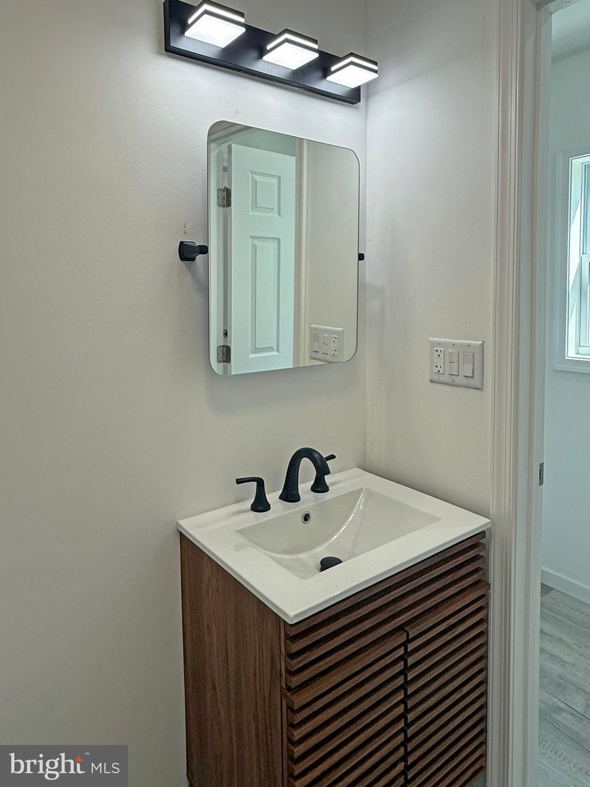 33308 Lighthouse Court, Unit D18 Lewes, DE 19958 - Photo 26 of 39 a bathroom with a sink and a mirror