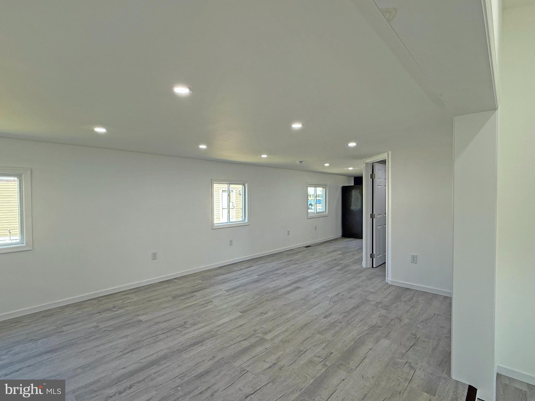 33308 Lighthouse Court, Unit D18 Lewes, DE 19958 - Photo 4 of 39 an empty room with wooden floor and window